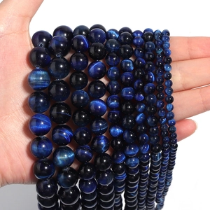 Detailed view of various sizes of blue tiger eye round beads with chatoyancy effect