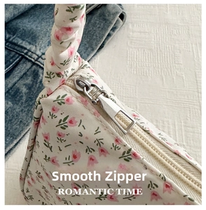 Detail of silver smooth zipper and rope handle on floral tulip shoulder bag