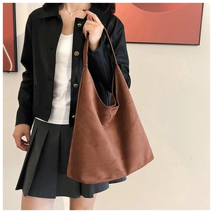Brown suede tote bag worn on shoulder showing large capacity and soft matte texture