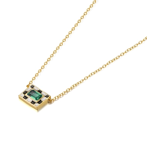 Macro detail of Art Deco silver necklace with emerald stone and enamel pattern