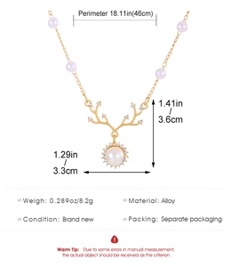 Detail of gold reindeer necklace with dimensions showing pearl and crystal elk pendant