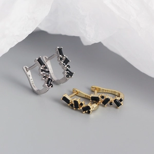 Detail of silver and gold U-shaped 925 silver earrings with black rectangular zircons