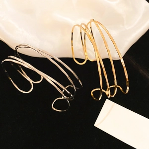 Detailed close-up of textured gold and silver multi-layer irregular open cuff bracelets