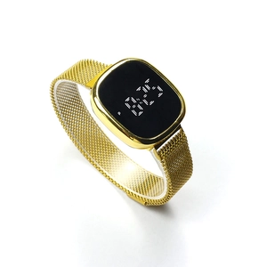 Gros plan du bracelet en maille dorée et de l'écran LED tactile noir de la montre