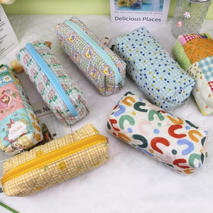 Flat lay of quilted cotton pouches featuring various floral and geometric patterns with zippers