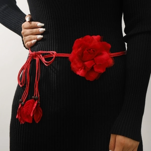 Close-up of red chiffon flower waist chain with braided rope and tassel details