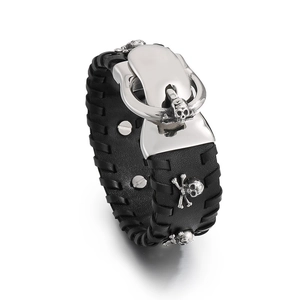 Punk black leather bracelet with silver skull charm and alloy clasp on white background