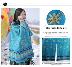 Close-up of blue ethnic cashmere shawl with floral embroidery and tassel detail