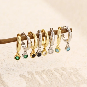 Macro shot of colorful zircon stones on gold and silver 925 sterling silver huggie earrings