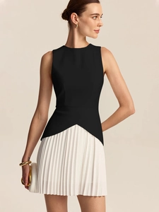 Detail of elegant waist pleats on women's sleeveless black top and white mini skirt