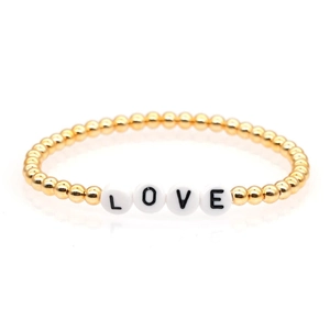 Detailed view of gold beaded bracelet with LOVE letter charms on a clean white background
