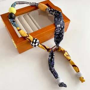 Ethnic bohemian fabric printed necklace with large colorful wooden beads on wood box