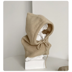 Detail of beige ribbed knit balaclava with drawstring on a white display stand