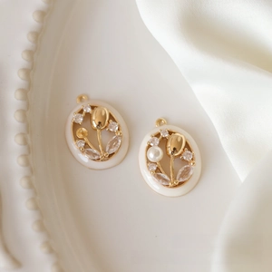 Detailed view of gold tulip flower oval pendants with white pearls for DIY jewelry making