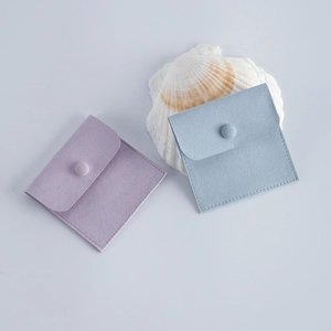 Detailed view of small purple and blue velvet jewelry pouches with round snap closures