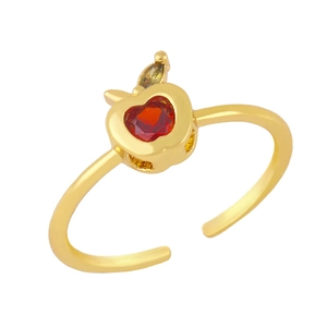 Detail of apple ring with red heart zircon and green leaf on golden adjustable band