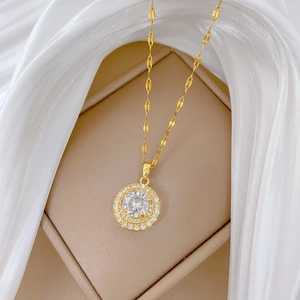 Detailed close-up of a luxury gold-plated necklace with a crystal-studded circular pendant