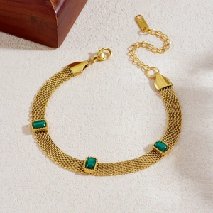 Bracelet en maille d'acier inoxydable doré avec cristaux rectangulaires verts sur fond beige