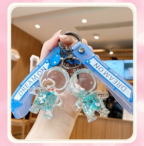 Detail of blue astronaut liquid quicksand keychain with Dream On silicone strap and clasp