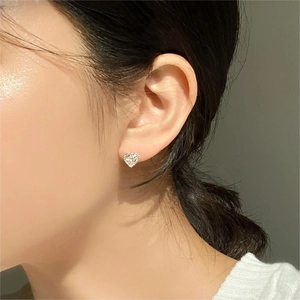 Elegant 925 sterling silver heart stud earrings with cubic zirconia stones on female ear