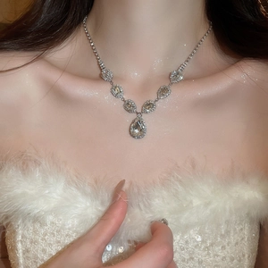 Close-up of sparkling silver geometric necklace with teardrop rhinestones on model
