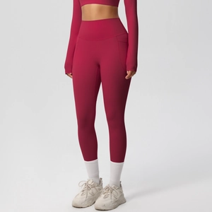 Detail of high-waisted dark red yoga pants featuring functional side pockets and seamless fabric
