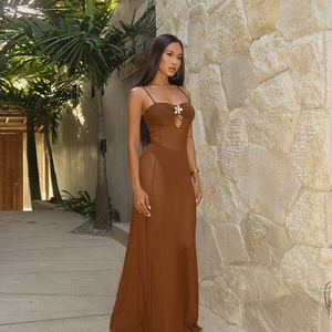 Détail de la fleur blanche en relief sur une robe longue marron en tulle transparent
