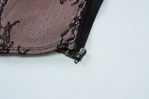 Détail d'un corsage en dentelle noire avec doublure chair et fermeture éclair de qualité