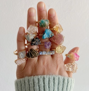 Macro detail of handmade wire wrapped rings with various natural raw crystal gemstones