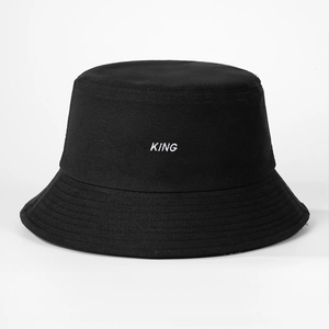 Detail of black cotton bucket hat featuring white KING letter embroidery on the front