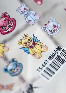 Macro shot of 5D embossed nail art stickers featuring cartoon demonic bear designs