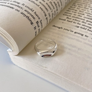 Minimalist 925 sterling silver irregular ring with polished finish on a book