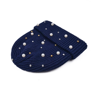 Dettaglio del berretto in maglia blu navy con perle sintetiche e perline oro e argento
