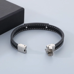 Detail of black leather bracelet with white stitching and silver clasp in a gift box
