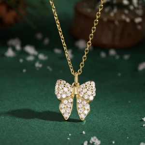 Macro shot of 925 silver bow pendant with cubic zirconia on a festive green background