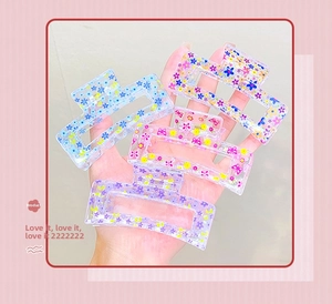 Set of four large transparent rectangular hair claws with colorful floral patterns