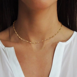 Minimalist golden bead chain necklace in stainless steel worn on a model's neck