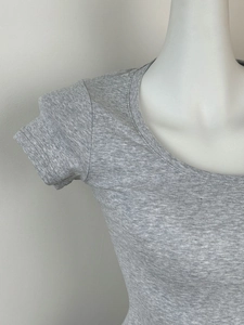 Close-up of gray ribbed knit fabric texture on a slim fit U-neck short sleeve T-shirt