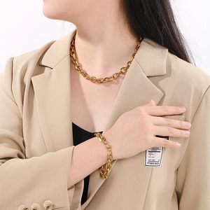 Dettaglio di un modello che indossa un set collana e bracciale in acciaio inox dorato