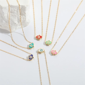 Golden Hamsa hand necklaces with colorful evil eye enamel pendants on stone base