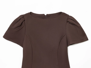 Detailed close-up of brown short sleeve dress featuring round neck and pleated fabric texture