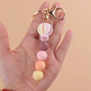 Pink hot air balloon silicone beaded keychain with gold metal ring held in hand