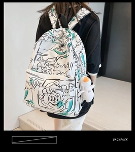 Rear view of a white graffiti backpack featuring a cute plush duck charm and straps