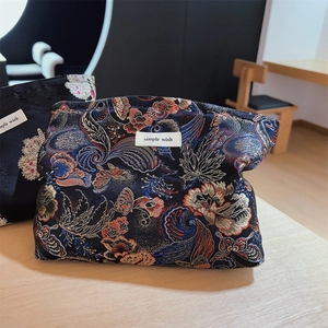 Close-up of brocade fabric with floral jacquard and a simple wish label on the makeup bag