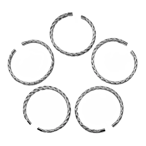 Close-up of five silver textured mesh twist bracelets with polished ends on white background