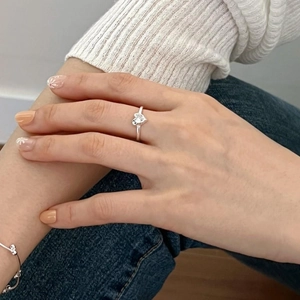 Detail of 925 sterling silver heart ring with zircon stone worn in a casual lifestyle setting