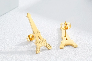 Détail de boucles d'oreilles clous tour Eiffel dorées en acier inoxydable poli