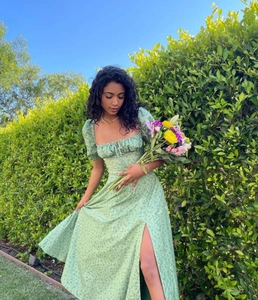 Detail of green floral maxi dress featuring puff sleeves and front drawstring design
