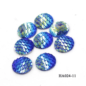 Macro detail of 12mm round blue-green gradient fish scale resin cabochons with AB finish
