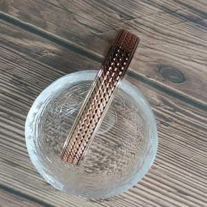 Close-up of twisted rope texture on a copper magnetic therapy bracelet over crystal